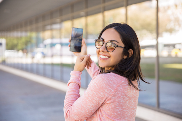 Happy woman taking pictures in her hometown.