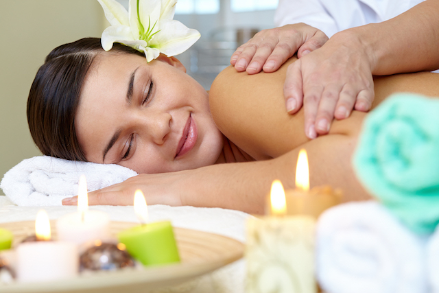 woman smiling enjoying a spa massage.