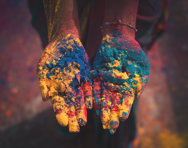 hands holding different dry colors for Holi.