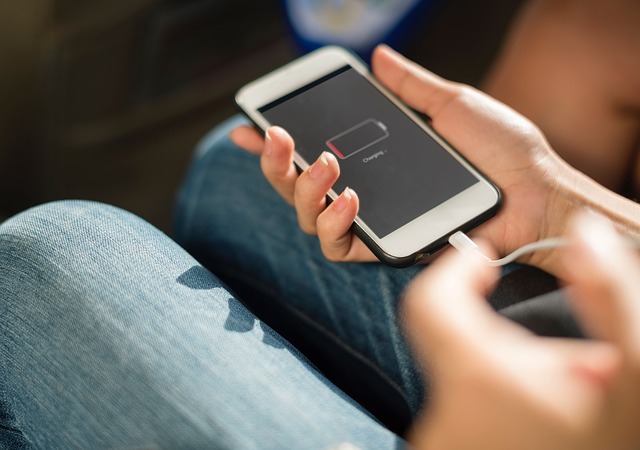 a dead phone using a charging cable to recharge.