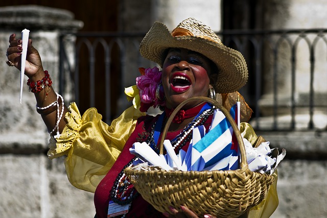 woman handing out souvenirs at a street festival in Havana. 