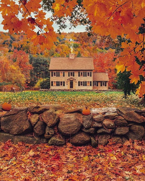 house in Stowe, Vermont surrounded by colorful fall foliage.